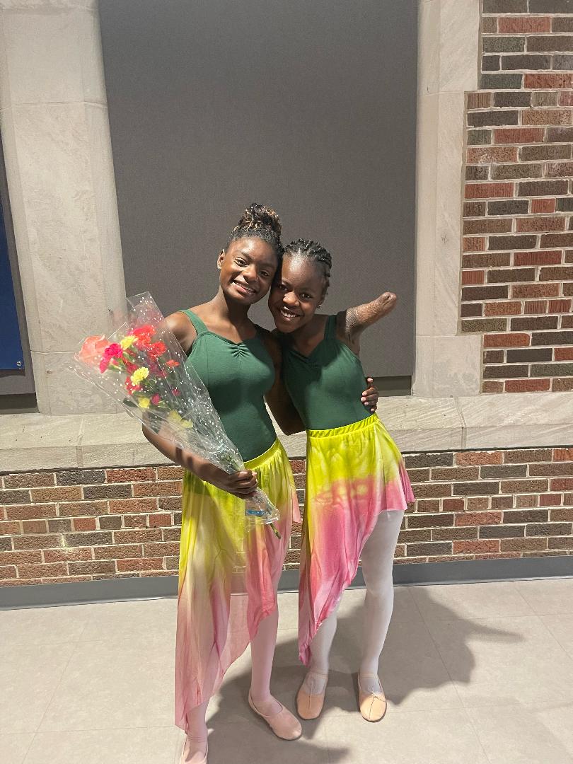 Two Young Ballet Students Posing With Flowers